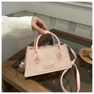 Detail of pink leather trim and woven straw texture on this stylish handbag