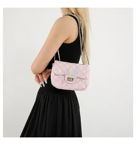 Détail du petit sac rose matelassé avec broderie colorée et bandoulière en chaîne