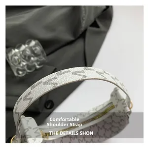Detail of comfortable shoulder strap and monogram pattern on a vintage hobo bag