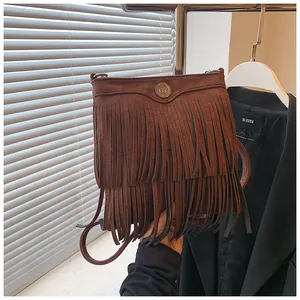 Detail shot of brown frosted suede crossbody bag featuring long double-layered fringe trim