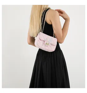 Détail du sac bandoulière en tweed rose matelassé avec broderie et chaîne dorée