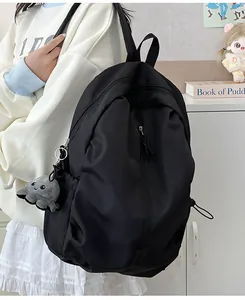 Detailansicht eines schwarzen Nylon-Rucksacks mit einem süßen Oktopus-Plüsch-Schlüsselanhänger