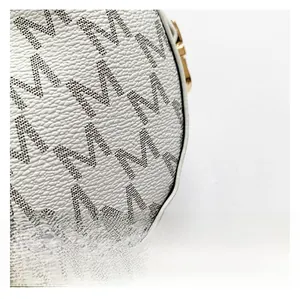 Macro shot of white lychee texture fabric with M-letter print and golden hardware hook