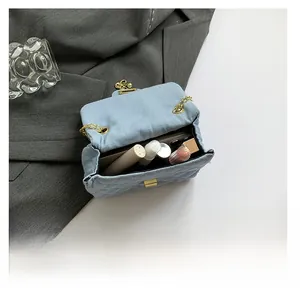 Interior view of light blue quilted denim crossbody bag showing large storage capacity