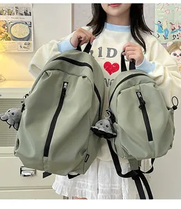 Detailansicht von großen und kleinen grünen wasserdichten Nylon-Rucksäcken mit Anhängern