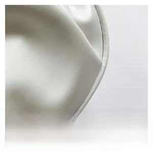 Macro detail of creamy white lychee grain leather texture and neat stitching on shoulder bag