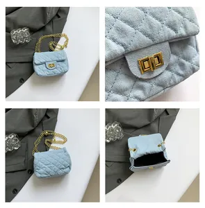 Detail view of light blue quilted crossbody bag with gold chain and metal twist lock