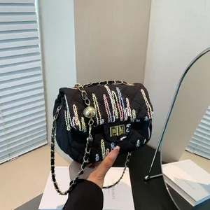 Sac bandoulière noir matelassé avec broderie colorée et bandoulière chaîne dorée
