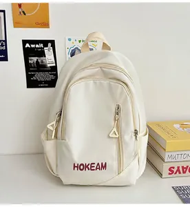 Detail of cream nylon backpack featuring HOKEAM print and unique triangle zipper pulls
