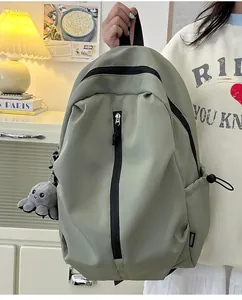 Detail eines graugrünen Nylon-Rucksacks mit Modelabel und Plüsch-Oktopus-Anhänger