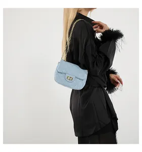 Detail of light blue quilted crossbody bag with gold chain strap and turn-lock closure
