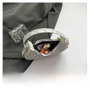 Internal view of beige monogram baguette bag showing storage for phone and cosmetics