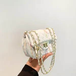 Petit sac blanc matelassé avec coutures colorées et bandoulière chaîne dorée élégante