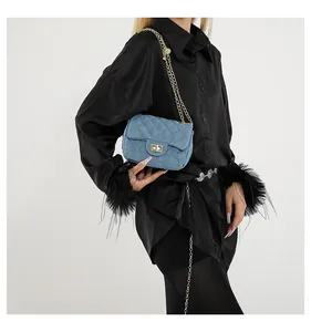 Detail of blue denim crossbody bag featuring quilted rhombus patterns and gold chain
