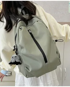 Leichter bohnen grüner Nylon-Rucksack mit Oktopus-Anhänger auf dem Modellrücken