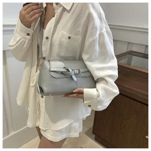 Detail van de zilveren crossbodytas met metallic afwerking en gouden gesp