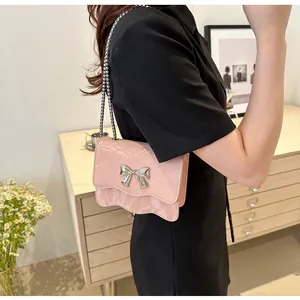 Detail of pink marble textured crossbody bag featuring a silver bow and metal chain strap