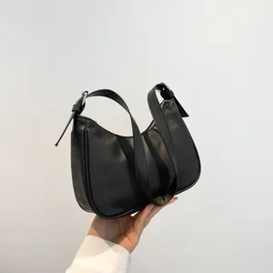 Minimalist black quilted leather crescent shoulder bag with adjustable silver buckle