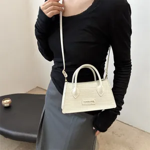 Off-white textured mini square bag with metal logo, versatile crossbody hand-held style
