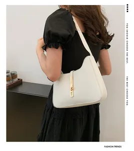 Minimalistische weiße Mondsichel-Schultertasche mit goldener Schließe und feiner Nahtverarbeitung