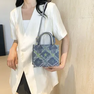 Sac à main en denim bleu foncé avec motif d'étoiles vertes et bords effilochés
