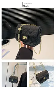 Detail of black denim quilted crossbody bag with gold chain strap and metal lock