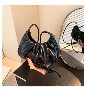 Detail shot of the black pleated PU leather dumpling bag with textured surface finish
