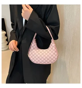 Detailed shot of pink hobo bag with M-pattern print and gold metal buckles