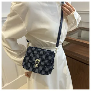 Détail du sac bandoulière à carreaux bleus avec franges et boucle dorée en forme de U