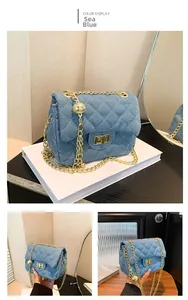 Detailed shot of quilted denim sea blue crossbody bag with gold chain and ball charm