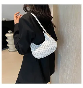Detail of white moon-shaped hobo bag with grey M-letter pattern and leather texture