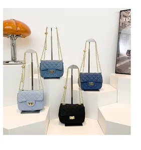 Close-up of quilted denim shoulder bags with golden chains and decorative metal balls