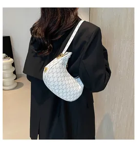 Detail of white half-moon shoulder bag with grey M-letter print and gold buckle
