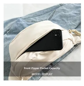 Front zipper pocket of beige nylon crossbody bag showing storage capacity for a smartphone