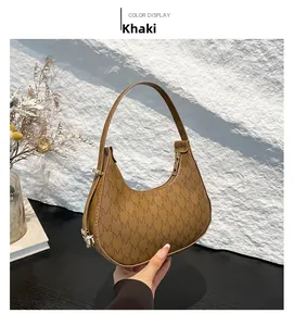 Detail view of khaki hobo bag with M-pattern print and gold zipper hardware