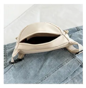 Detailed interior view of a beige nylon crescent crossbody bag with dark lining