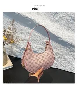 Detailed view of pink hobo bag with M-pattern print and elegant golden hardware