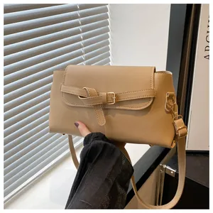 Close-up of beige matte PU leather handbag with decorative knot and flap closure