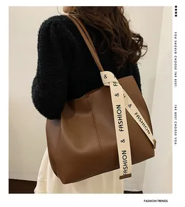 Detail of dark brown tote bag featuring printed strap accent and matte leather finish
