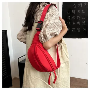 Detail view of the red nylon waist bag with adjustable straps and sturdy black buckle