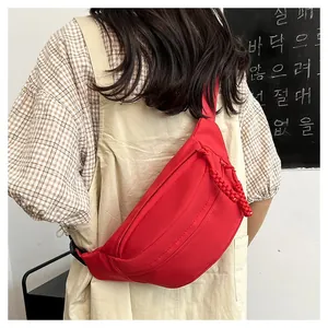 Detail of a bright red canvas crossbody bag with adjustable strap and zip closure