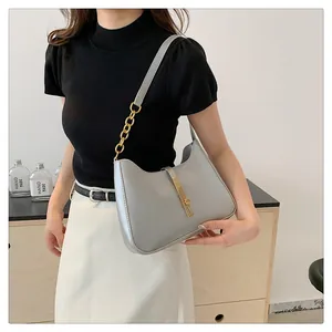 Detail der hellgrauen Hobo-Tasche mit goldener Kette und Schnalle auf der Schulter