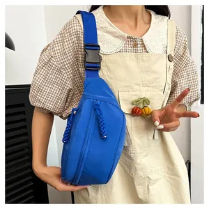 Detail of royal blue nylon chest bag showing zipper closure and woven rope puller