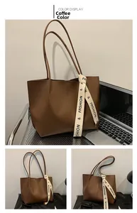 Detail view of coffee brown tote bag in office setting with sleek leather texture