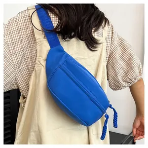 Detail showing Klein blue nylon waist bag with woven rope zipper on a model back