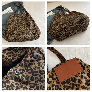 Detail view of leopard print tote bag showing snap button and leather logo patch