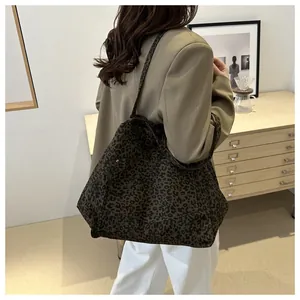 Leopard print canvas tote bag on model's shoulder in a cozy minimalist interior