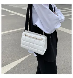 Dettaglio della borsa in pelle PU bianca trapuntata con catena dorata e cuciture raffinate