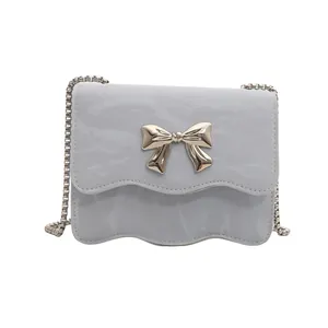 Light blue crossbody flap bag with silver metal bow and pleated texture finish