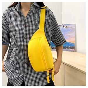 Detail of yellow nylon crossbody waist bag with double zipper and adjustable strap